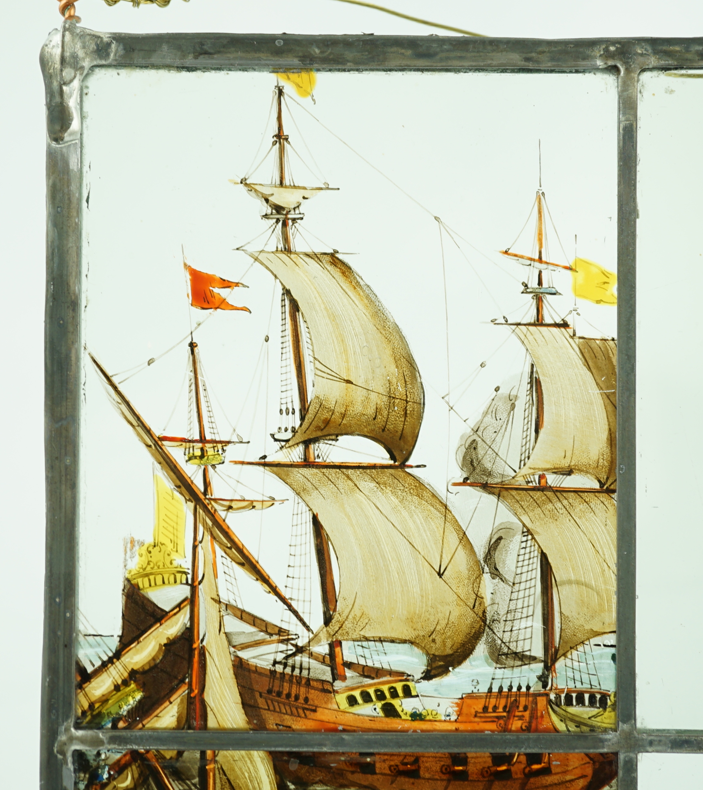 A 18th century Dutch stained glass panel made from four sections depicting a shipwreck and the sails of a fighting galleon, overall 28 x 23cm